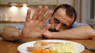 Мужчина отодвигает тарелку с едой