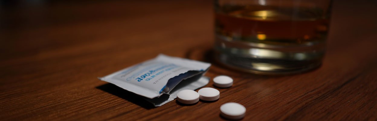 Таблетки аспирина и стакан алкоголя